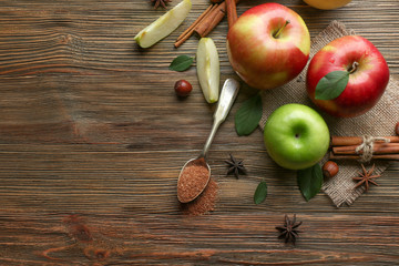 Composition with fresh apples and cinnamon on wooden table