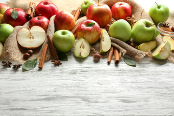 Fresh ripe apples and cinnamon on wooden background