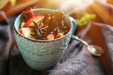 Cup of tea with cinnamon and apples on table