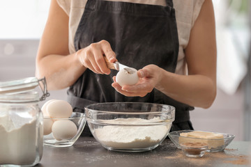 Woman making dough for cinnamon buns at table