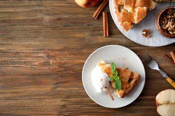 Composition with piece of delicious apple pie and ice cream on wooden background