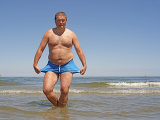 comic portrait of the fat man, doing the breast stroke in a water