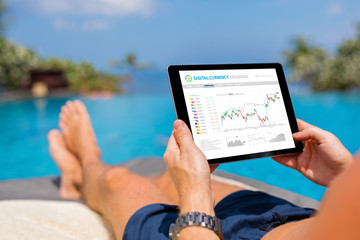 Man trading digital currencies online while relaxing by the pool.
