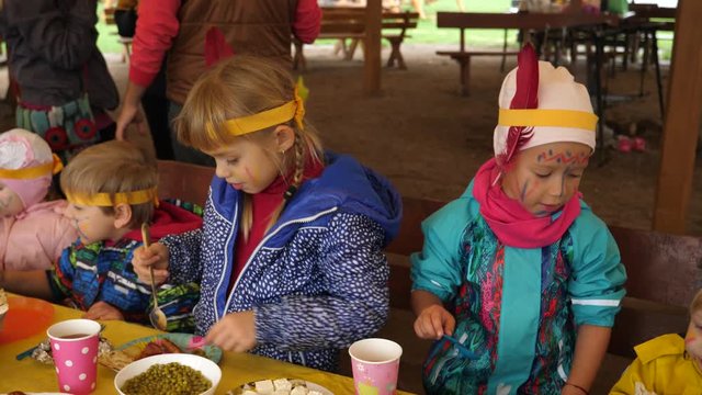 Children eating food dishes at colorful birthday party celebration