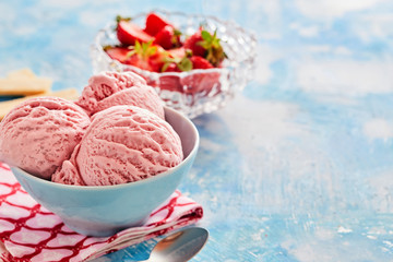 Delicious strawberry  ice cream sundae on bright blue background