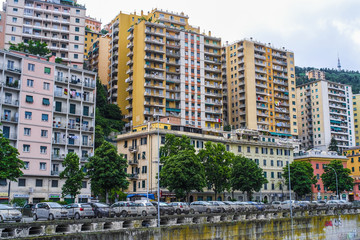Fototapeta na wymiar Genoa, Italy - June, 12, 2018: residential district in Genoa on an embankment of river, Italy