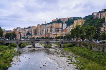 Genoa, Italy - June, 12, 2018:  residential district of Genoa on an embankment of river, Italy
