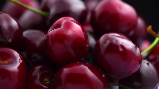Cherry. Organic ripe cherries rotated closeup over black background. Rotation 4K UHD video 3840X2160