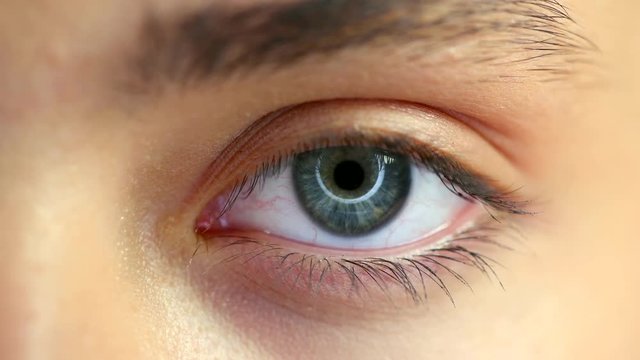 Beautiful female blue eye closeup. Young woman eye blinking and looking up. 4K UHD video 3840X2160