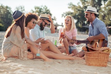 Group of happy young people having a picnic on the beach