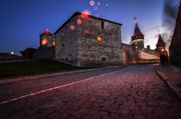 Landscape night photo of Fortress with lights and peoples` silhouettes