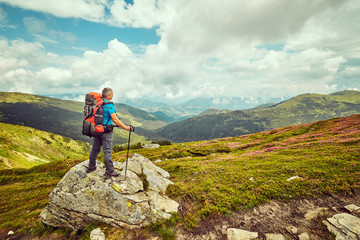 Man with red backpack enjoying landscape on cliff solo traveling healthy lifestyle concept active summer vacations