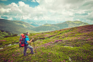 Fototapeta premium Man with red backpack enjoying landscape on cliff solo traveling healthy lifestyle concept active summer vacations
