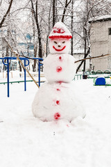 snowman at public urban yard in winter day