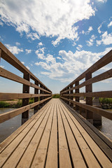 Holzbrücke über wasser mit leicht bewöltem Himmel