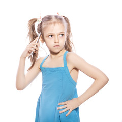 Young seven years old brunette girl in blue dress on a white isolated background. Angry emotions on her face. She unhappy about something, while talking on the phone