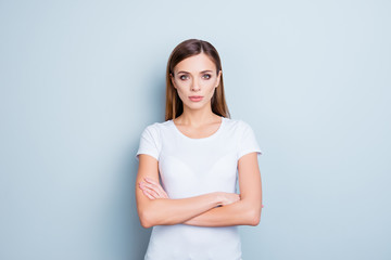 Fototapeta premium Portrait of perfect cute girl in white t-shirt having holding arms crossed isolated on grey background looking at camera