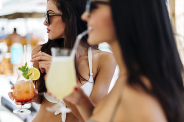 Fototapeta na wymiar Two beautiful girls drinking cocktails