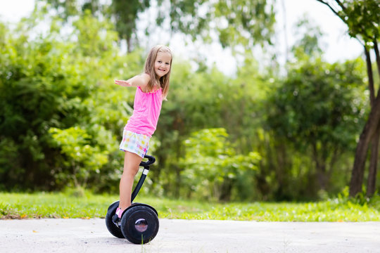 Child on hover board. Kids riding scooter
