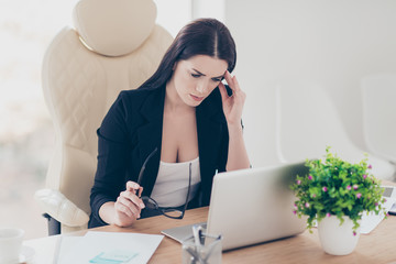 Portrait of sad upset accountant holding hand on temple suffering from syndrome symptom head ache feeling bad sitting at desktop. Health healthcare care concept