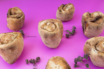 Buns with cinnamon on a light pink background