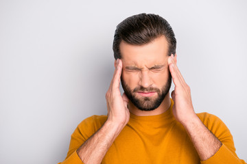 Close up portrait of unhealthy tired man touching his temples suffering from head ache isolated on...