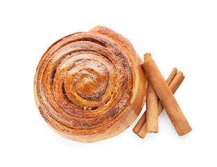 Delicious bun and cinnamon sticks on white background
