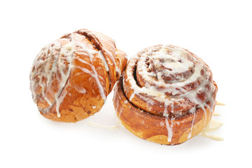 Tasty homemade cinnamon buns with glaze on white background