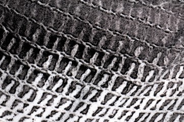 Close-up detail of decorated cotton fabric. For texture or background. Black and white tones.