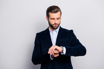 Portrait of serious focused smart intelligent thoughtful planning handsome economist wearing stylish trendy velvet jacket checkered shirt looking at silver modern watch isolated on gray background