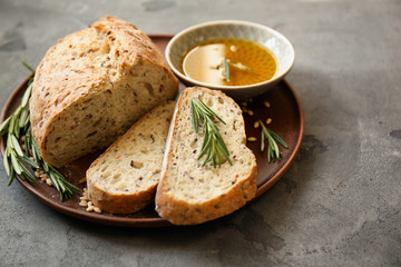 Plate with fresh tasty bread and oil on table