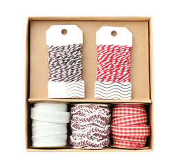 Obraz premium Box with ribbons and threads for scrapbooking on white background