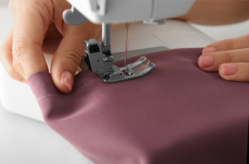 Female tailor using sewing machine, closeup