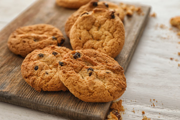 Board with delicious cookies on wooden background, closeup