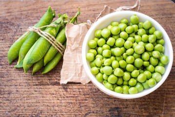A seeds of peas in a bowl on wooden background. Copy space