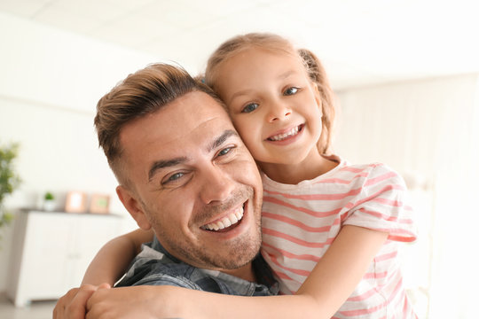 Portrait of happy father and daughter at home