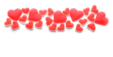 Heart-shaped candies on white background