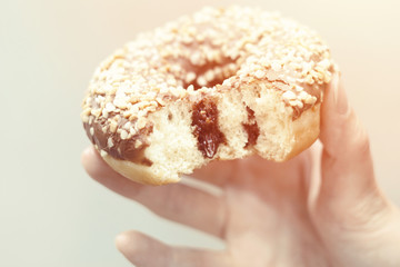 Beautiful young girl stuck out her tongue and tries to lick a donut. Fashionable hipster model in heart-shaped sunglasses. Close up. Mockup