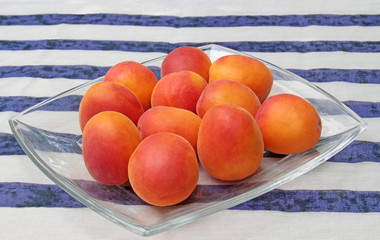 bowl with apricots on striped background