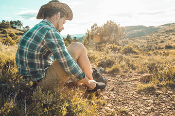 Man tying his boots on the mountain