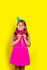 Studio portrait of a little girl wearing a party hat on her birthday.