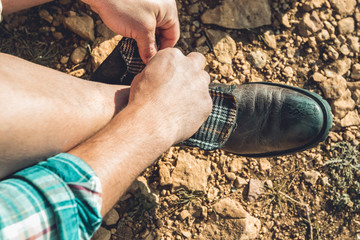 Man tying his boots on the mountain
