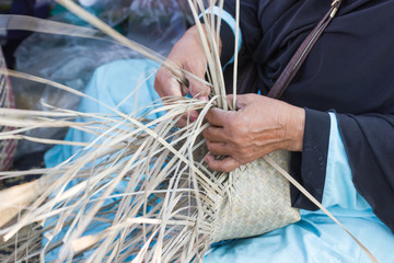 Motion Image - hand of woman holds The villagers took bamboo stripes to weave into different forms for daily use utensils of the community’s people in Bangkok Thailand, Thai handmade product.  