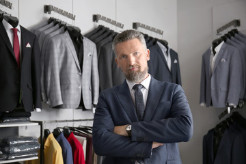 Handsome mature man in stylish suit at menswear store