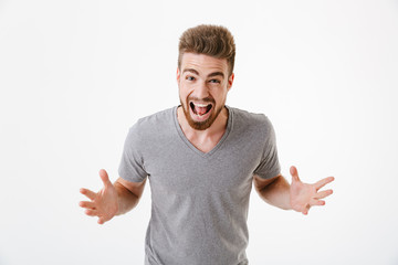 Excited emotional young man standing isolated