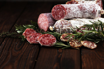 thinly sliced salami on a wooden texture on the background.