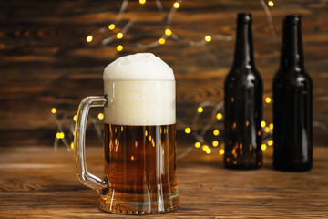 Glass mug with cold beer on wooden table