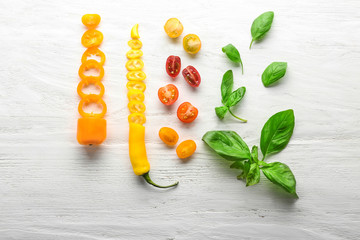 Composition with fresh basil and vegetables on wooden background