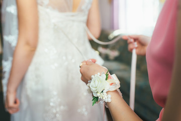 Obraz na płótnie Canvas Bridesmaid helps bride to clothing dress