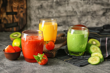 Glasses with fresh tasty smoothies and ingredients on table